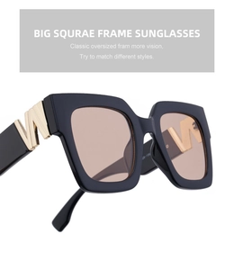 Detailed view of oversized square sunglasses with gold W metal accent on black frames