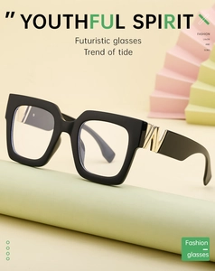 Detail of square glasses with gold W-shaped hinge and transparent blue light lens