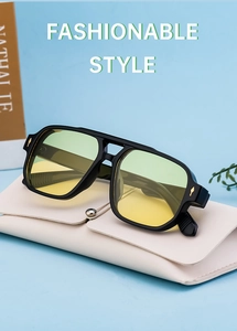 Detail of square black sunglasses with yellow lenses on a premium cream leather case