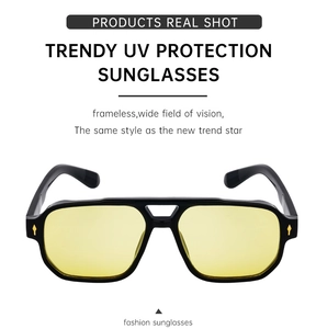 Macro shot of square aviator sunglasses featuring yellow lenses and gold arrow hinges