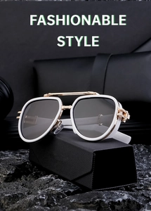 Detail of white aviator sunglasses with gold metal bridge on a black rock base