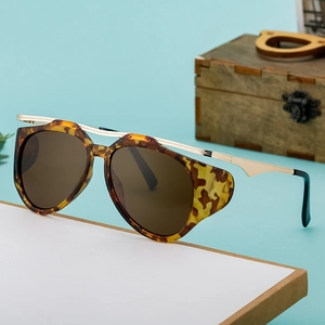 Chic cat eye sunglasses with leopard print frame and gold metal bridge on blue background