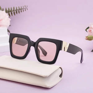 Chic square black sunglasses with pink lenses and gold metal accents on a case