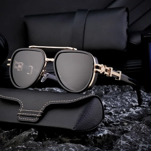 Men's polarized aviator sunglasses in black and gold with a leather case on dark stones