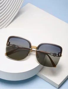 Detail of half-frame polarized sunglasses with gradient lenses and gold metal accents