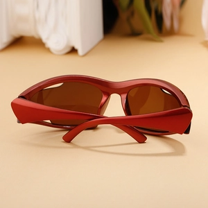 Close-up of sporty wrap-around sunglasses with red metallic frame and brown lenses