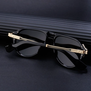 Detailed close-up of retro aviator sunglasses featuring black frames and gold metal temple accents
