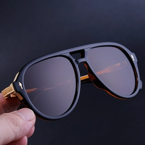 Detail of pilot sunglasses hinge with golden stripes and side arrow accents on matte frame