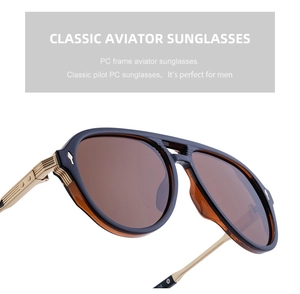 Detail of aviator sunglasses showing gold metal hinges and brown resin lenses for men