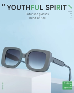 Detail of grey square frame sunglasses with blue-grey gradient lenses on white steps