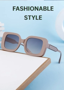 Detail view of square sunglasses with light brown frame and gradient lenses on a blue background