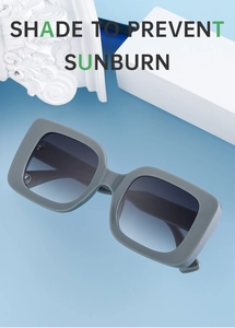 Detail view of gray square sunglasses with gradient lenses on a minimalist background
