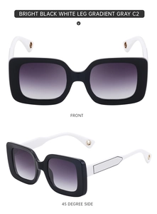 Detail of square oversized sunglasses with white temples and golden logo accents