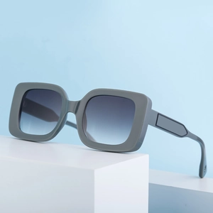 Modern square frame sunglasses with grey matte finish and gradient lenses on blue background