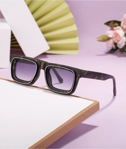 Détail de lunettes de soleil carrées avec monture écaillée et verres dégradés violets