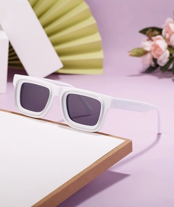 Vue détaillée de lunettes de soleil blanches à monture épaisse et verres gris foncé