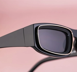Macro detail of black sunglasses with gold metal trim and rectangle frame design