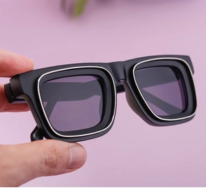 Détail de lunettes de soleil carrées avec monture noire mate et bordure argentée