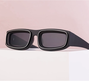 Detail of square sunglasses with silver trim and grey lenses on a white pedestal