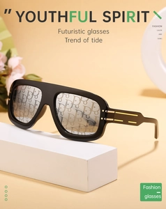 Detail of square sunglasses featuring golden metal trim and logo-patterned lenses