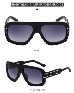 Close-up of oversized square sunglasses with silver metal trim and gradient gray lenses
