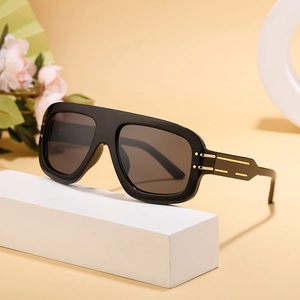 Chic square frame sunglasses with gold temple accents on a minimalist display stand