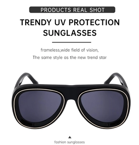 Détail de lunettes aviateur noires avec bordure dorée et verres de protection UV