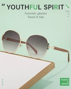 Detail of round gold metal frame sunglasses with gradient lenses and thick brown temples