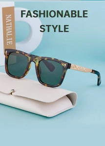 Detail view of tortoiseshell sunglasses with engraved gold metal temples and leather case