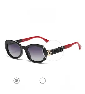 Detail of oversized sunglasses with black chain temples and gold floral accents