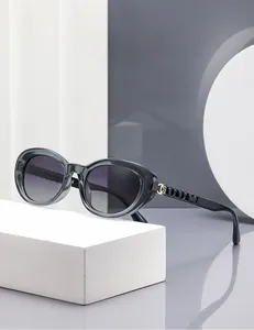 Detail of grey polarized sunglasses with woven chain temples and gold floral hinge accents
