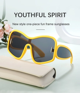 Detail of bright yellow oversized one-piece sunglasses with grey lenses and leather case