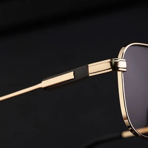Makrodetail der goldfarbenen Metallscharniere und Bügel an der quadratischen Herrensonnenbrille