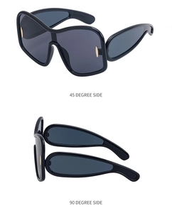 Detail view of large frame sunglasses with side shield lenses and gold accents