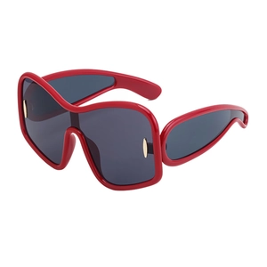 Red oversized sunglasses with dark lenses and gold metal accents in a 45-degree side view