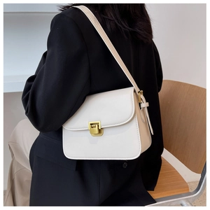 Rear view of model wearing a cream white rectangular shoulder bag with golden buckle