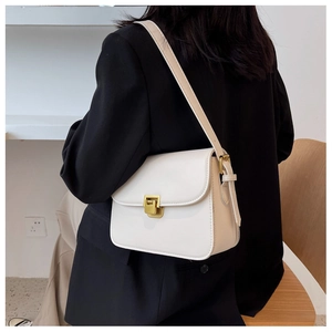 Close-up of a vintage white crossbody bag with elegant square gold metal buckle detail