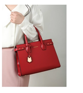 Dettaglio elegante borsa a mano rossa con grana litchi e borchie dorate