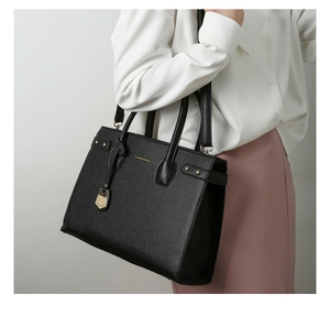 Dettaglio della borsa tote in pelle martellata nera con finiture in oro e scritta
