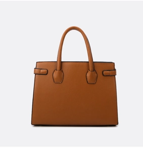 Dettaglio della borsa in pelle marrone con motivo litchi e fibbie decorative laterali