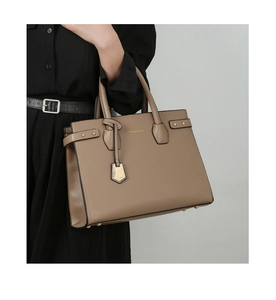 Dettaglio della borsa tote in pelle litchi kaki con rivetti dorati e manici robusti