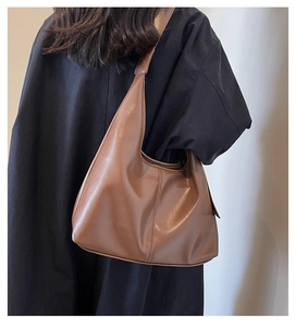 Sac hobo marron foncé porté épaule avec coutures précises et bandoulière large