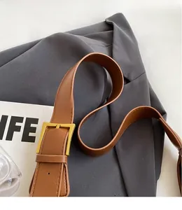 Détail de la bandoulière réglable en cuir marron avec boucle en métal doré chic