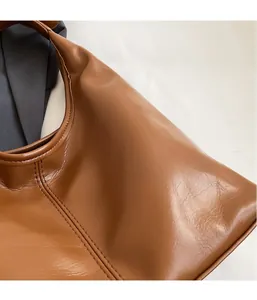 Gros plan sur la texture en similicuir marron caramel d'un grand sac seau pour femme