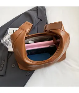 Intérieur spacieux d'un cabas en cuir marron foncé avec tablette et essentiels