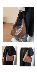 Détails de la texture cuir marron foncé et bandoulière large sur ce sac seau hobo chic