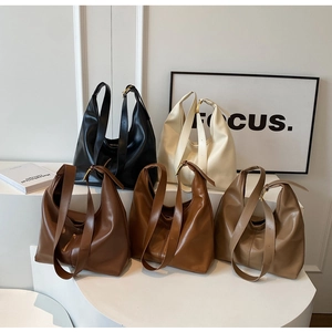 Cinq sacs Hobo minimalistes de différentes couleurs sur un support géométrique