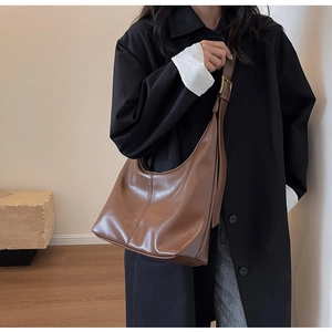 Détail de la texture en cuir marron et des coutures sur le sac à bandoulière moderne