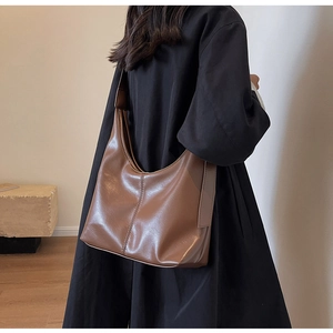 Détail de sac bandoulière en cuir marron foncé brillant avec texture de couture verticale
