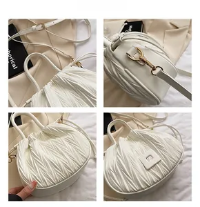 Detailed views of white pleated PU leather handbag showing gold hardware and texture